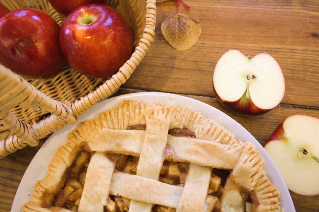 Table holding a basket of apple and an apple pie