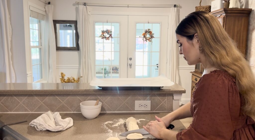 Girl dividing dough into equal parts.