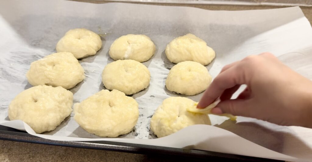 Applying egg wash on a sourdough bagel.