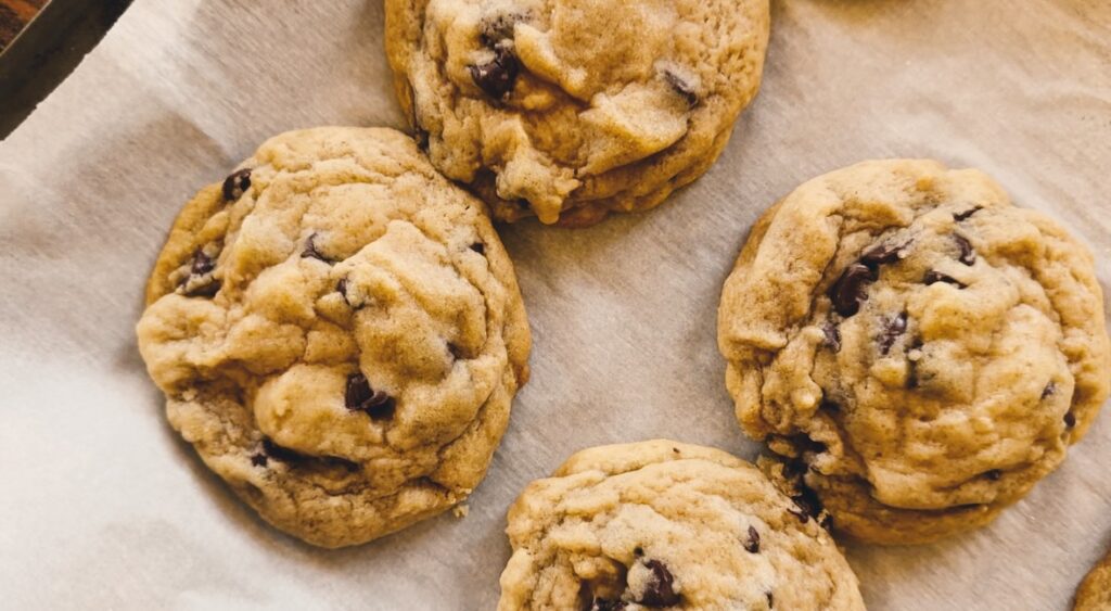 Parchment paper holding chocolate chip cookies.