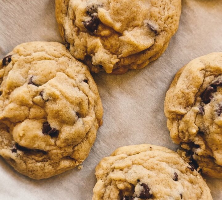 Parchment paper holding chocolate chip cookies.