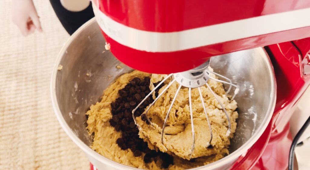 A mixer bowl containing cookie dough batter.