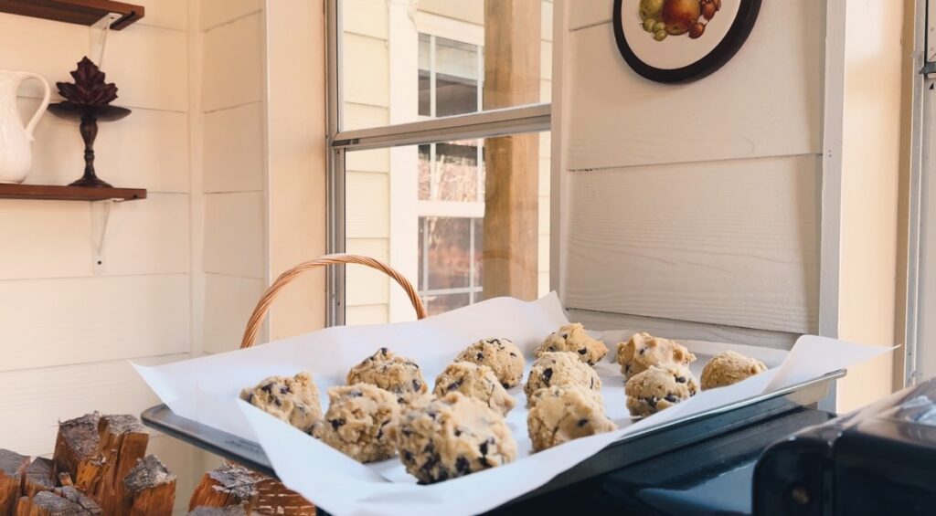 A view of chocolate chip cookie batter on a cookie sheet.