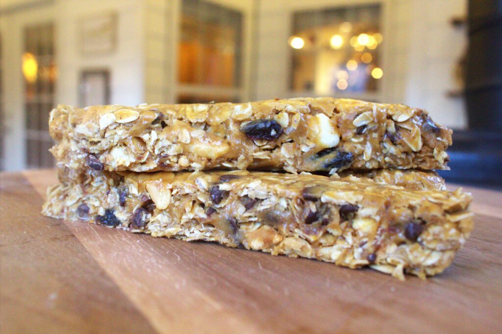 A wood table holding 2 granola bars stacked on top of each tother.